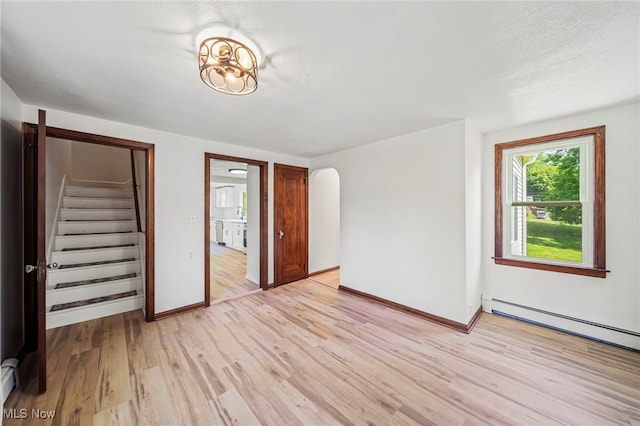 416 N Hambden St, Chardon, OH 44024 - unfurnished bedroom featuring light wood-style floors, arched walkways, and baseboard heating