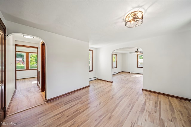 416 N Hambden St, Chardon, OH 44024 - unfurnished living room with arched walkways, plenty of natural light, and light wood-type flooring