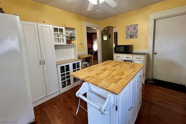 623 N 7th St, Marietta, OH 45750 - kitchen with freestanding refrigerator, arched walkways, butcher block countertops, dark wood finished floors, and white cabinets