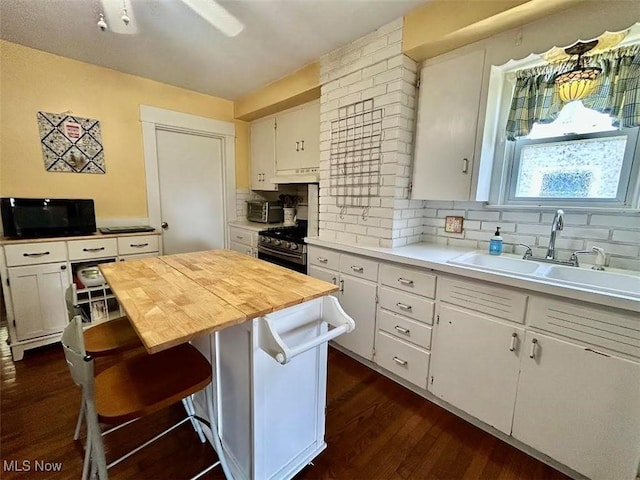 623 N 7th St, Marietta, OH 45750 - kitchen with gas range, wood counters, tasteful backsplash, white cabinetry, and black microwave