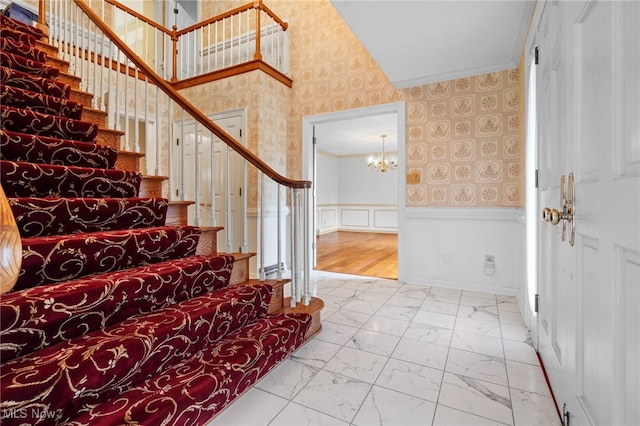 8640 Foxglove Ave NW, Clinton, OH 44216 - foyer with crown molding, a chandelier, marble finish flooring, wallpapered walls, and stairway
