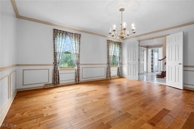 8640 Foxglove Ave NW, Clinton, OH 44216 - spare room featuring crown molding, a chandelier, healthy amount of natural light, a decorative wall, and light wood-style flooring