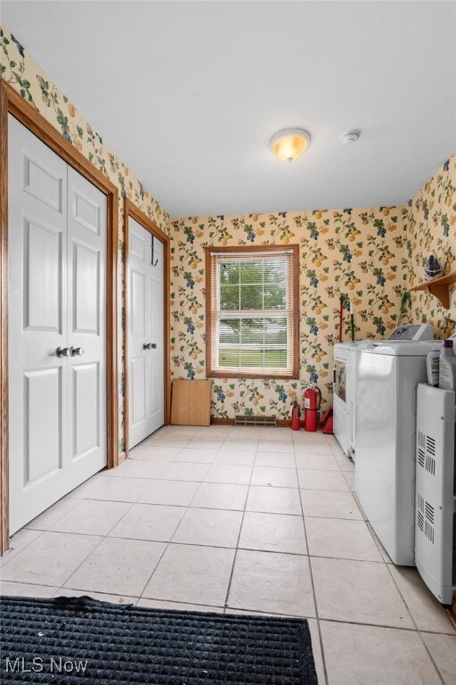 8640 Foxglove Ave NW, Clinton, OH 44216 - washroom with wallpapered walls, washer and dryer, and light tile patterned floors