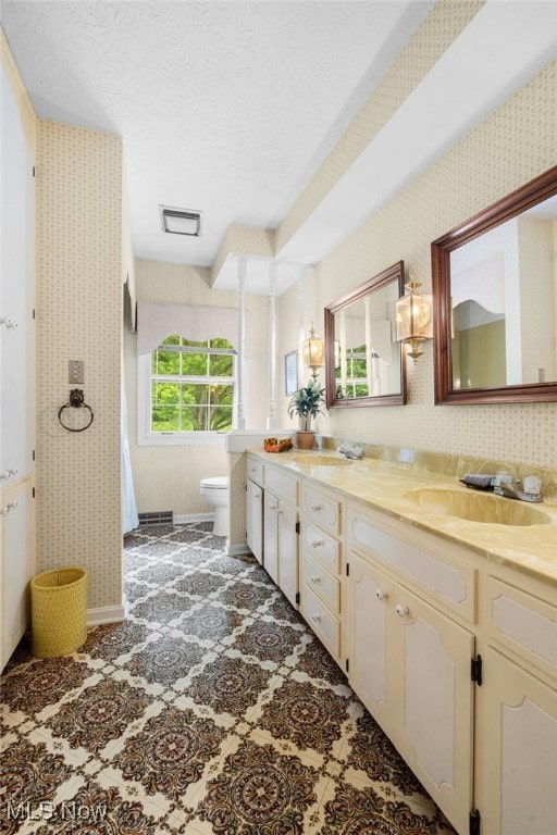 8640 Foxglove Ave NW, Clinton, OH 44216 - full bath featuring wallpapered walls, double vanity, and a textured ceiling