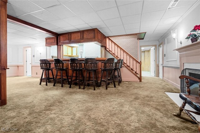8640 Foxglove Ave NW, Clinton, OH 44216 - dining room featuring carpet floors, stairway, a fireplace with flush hearth, a drop ceiling, and a dry bar
