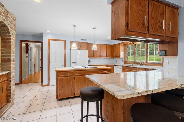 8640 Foxglove Ave NW, Clinton, OH 44216 - kitchen featuring white appliances, a peninsula, brown cabinets, light tile patterned flooring, and recessed lighting