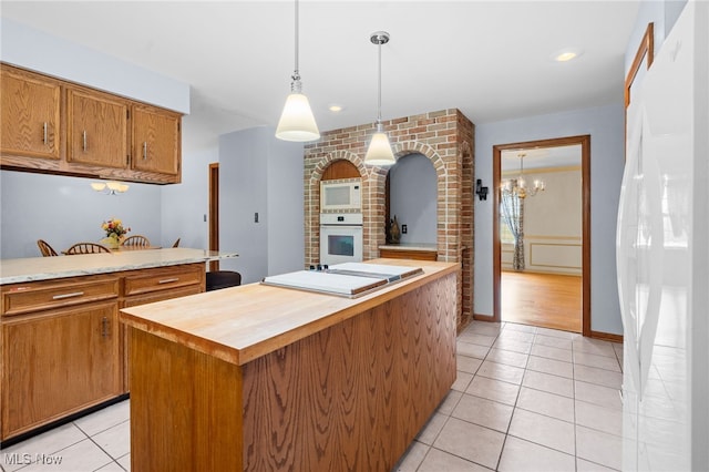 8640 Foxglove Ave NW, Clinton, OH 44216 - kitchen with white appliances, butcher block counters, brown cabinets, light tile patterned flooring, and a center island