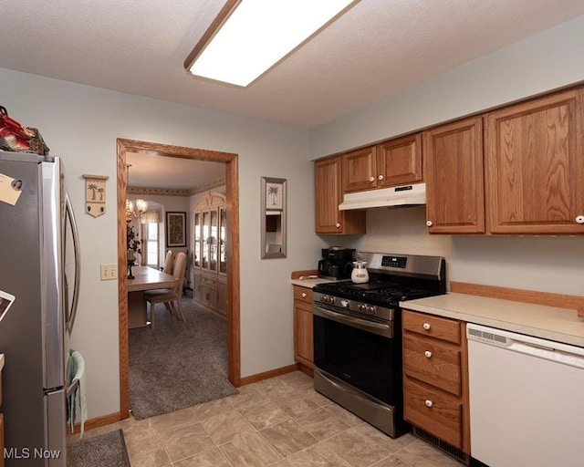 4053 Quail Ct, Ashtabula, OH 44004 - kitchen featuring stainless steel appliances, under cabinet range hood, brown cabinetry, light countertops, and a chandelier
