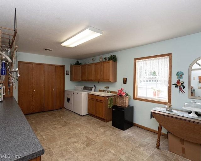 4053 Quail Ct, Ashtabula, OH 44004 - kitchen with washing machine and dryer and brown cabinetry