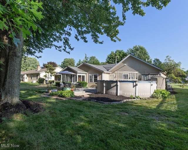 4053 Quail Ct, Ashtabula, OH 44004 - rear view of property featuring a yard, a patio area, and an outdoor pool