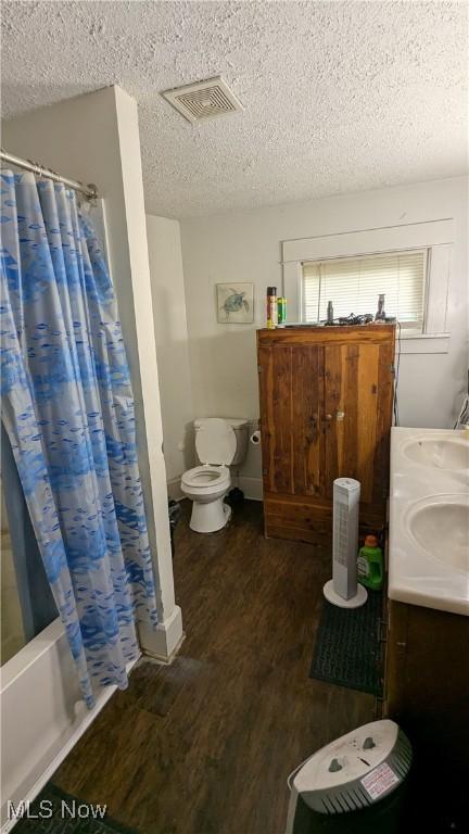 2310 7th St SW, Canton, OH 44706 - full bath featuring wood finished floors, a textured ceiling, shower / bath combo with shower curtain, and double vanity