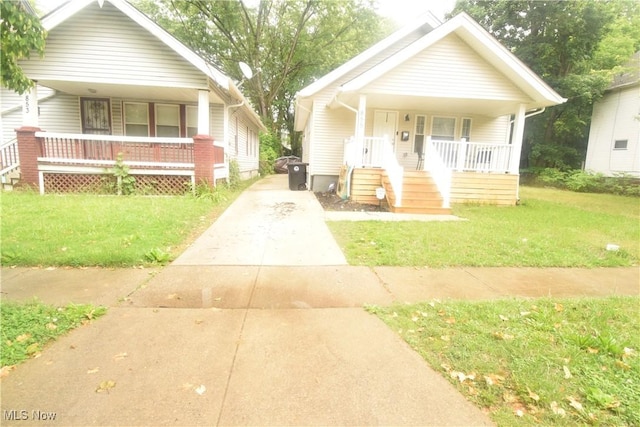 853 E 144th St, Cleveland, OH 44110 - bungalow-style home featuring covered porch, concrete driveway, a front lawn, and stairway