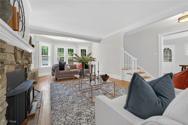 3294 Avalon Rd, Shaker Heights, OH 44120 - living room with wood finished floors, stairs, ornamental molding, and a stone fireplace
