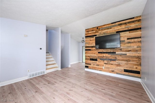 6633 Tamarind Dr, Bedford Heights, OH 44146 - unfurnished living room with wood finished floors, vaulted ceiling, wooden walls, and stairs