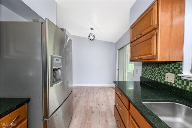 6633 Tamarind Dr, Bedford Heights, OH 44146 - kitchen with stainless steel refrigerator with ice dispenser, light wood-style floors, brown cabinetry, backsplash, and dark stone countertops