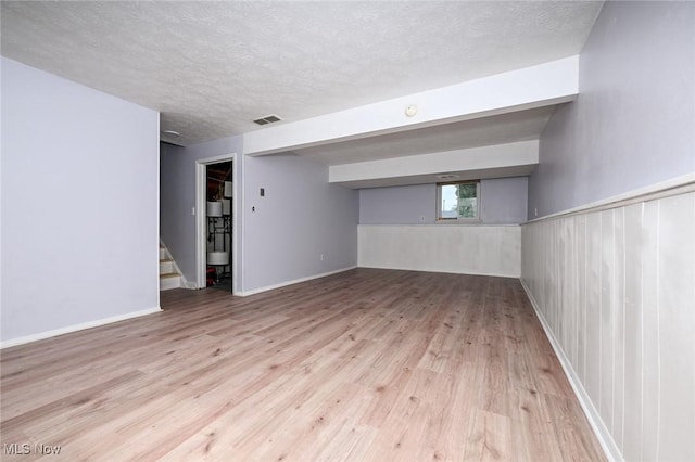 6633 Tamarind Dr, Bedford Heights, OH 44146 - basement with wood finished floors, stairway, and a textured ceiling