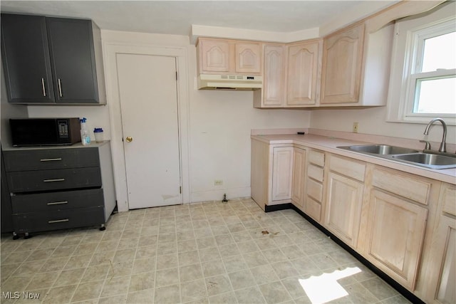 874 Cleveland Ave, Amherst, OH 44001 - kitchen featuring black microwave, light brown cabinetry, under cabinet range hood, and light countertops