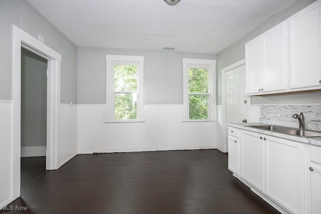 8023 Kosciuszko Ave, Cleveland, OH 44103 - kitchen featuring dark wood-style floors, white cabinetry, a wainscoted wall, light countertops, and backsplash