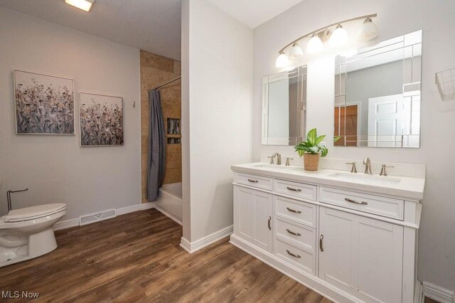 2692 Aspen Dr, Girard, OH 44420 - full bathroom with double vanity, wood finished floors, and shower / bath combo with shower curtain