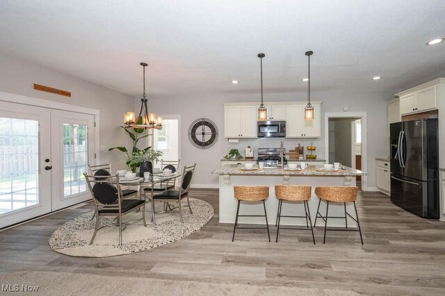 2692 Aspen Dr, Girard, OH 44420 - kitchen featuring black fridge with ice dispenser, stainless steel microwave, french doors, recessed lighting, and light wood finished floors