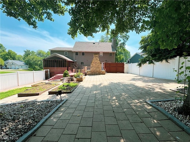 5123 Glenbrook Dr, Vienna, WV 26105 - fenced backyard with a garden, a patio area, and a sunroom