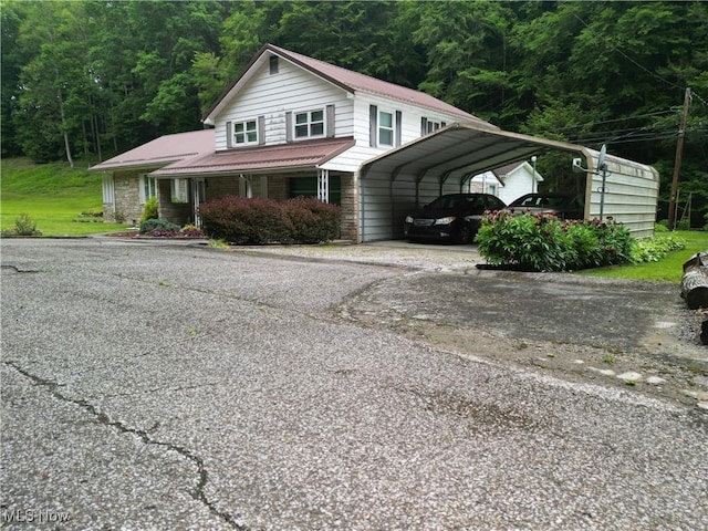 13088 Clay Hwy, Lizemores, WV 25125 - view of front facade with driveway, a detached carport, a forest view, and a metal roof