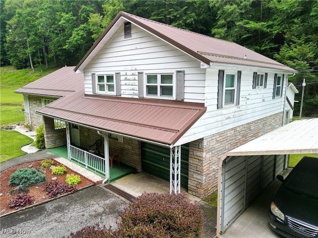 13088 Clay Hwy, Lizemores, WV 25125 - view of front of home with stone siding, covered porch, a forest view, and a metal roof