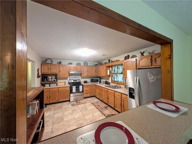963 Ivydale Rd, Clay, WV 25043 - kitchen featuring stainless steel appliances, a textured ceiling, light countertops, under cabinet range hood, and brown cabinets