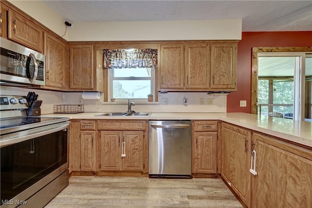 816 Vincent Dr, Loudonville, OH 44842 - kitchen featuring stainless steel appliances, light wood-style floors, light countertops, brown cabinets, and a textured ceiling