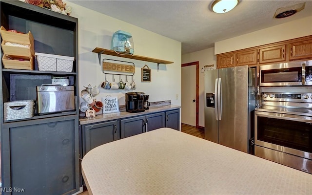 816 Vincent Dr, Loudonville, OH 44842 - kitchen featuring stainless steel appliances, light countertops, wood finished floors, open shelves, and brown cabinets