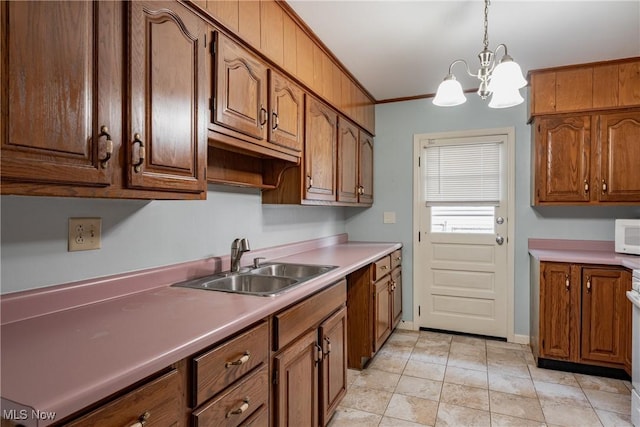 204 W 8 1/2 St, Williamstown, WV 26187 - kitchen with a chandelier, decorative light fixtures, white microwave, brown cabinets, and light countertops