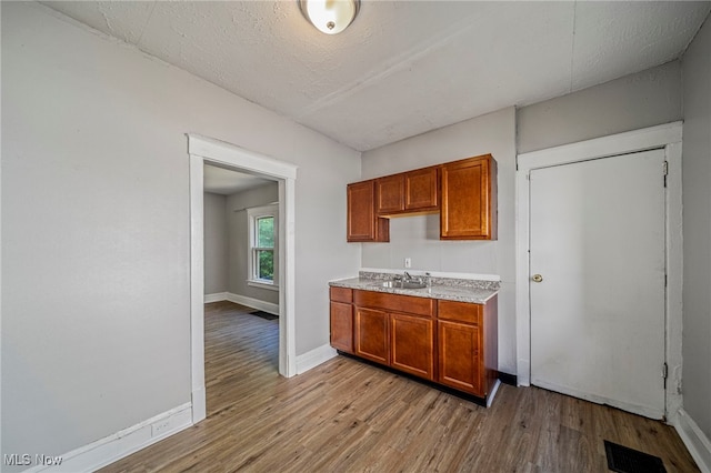 12525 Lancelot Ave, Cleveland, OH 44108 - kitchen featuring light wood-type flooring, brown cabinetry, and light countertops