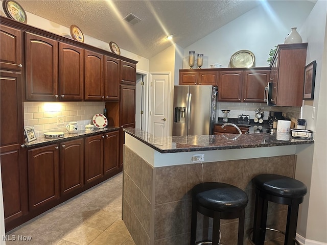 5-118 The Flds, Williamstown, WV 26187 - kitchen with stainless steel appliances, a peninsula, a kitchen breakfast bar, lofted ceiling, and backsplash