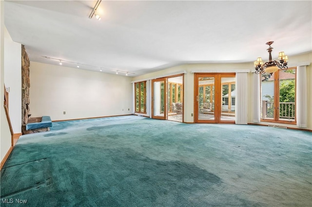 118 Steeplechase Ln, Munroe Falls, OH 44262 - unfurnished living room featuring rail lighting, a chandelier, and healthy amount of natural light
