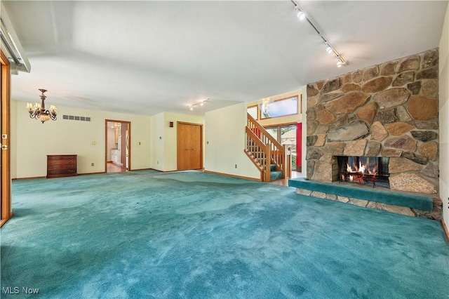 118 Steeplechase Ln, Munroe Falls, OH 44262 - unfurnished living room featuring rail lighting, stairs, a fireplace, and carpet