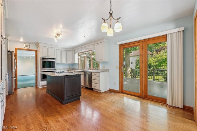 118 Steeplechase Ln, Munroe Falls, OH 44262 - kitchen featuring appliances with stainless steel finishes, white cabinets, a chandelier, and a kitchen island