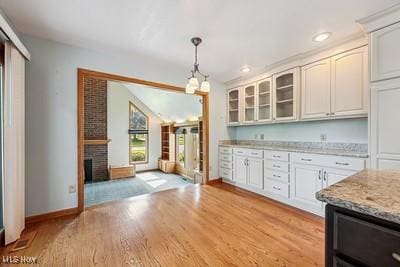 118 Steeplechase Ln, Munroe Falls, OH 44262 - kitchen with glass insert cabinets, light wood-style flooring, hanging light fixtures, recessed lighting, and light stone countertops