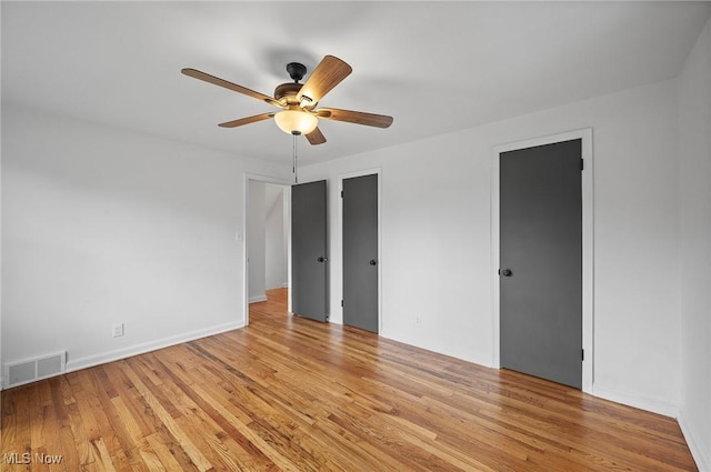 3722 Avalon Rd, Shaker Heights, OH 44120 - unfurnished bedroom with light wood-style floors, a ceiling fan, and multiple closets