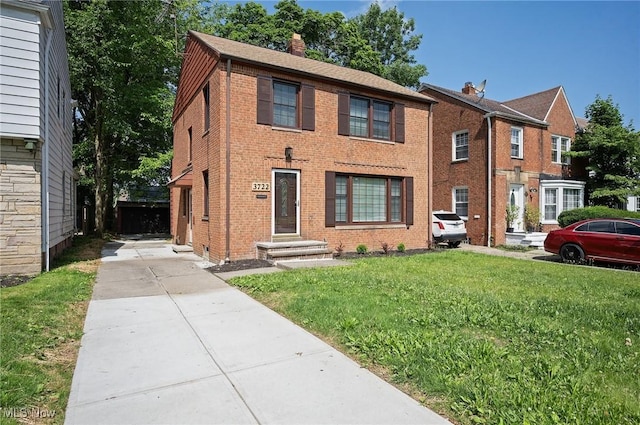 3722 Avalon Rd, Shaker Heights, OH 44120 - view of front facade with a chimney, brick siding, a front yard, and concrete driveway