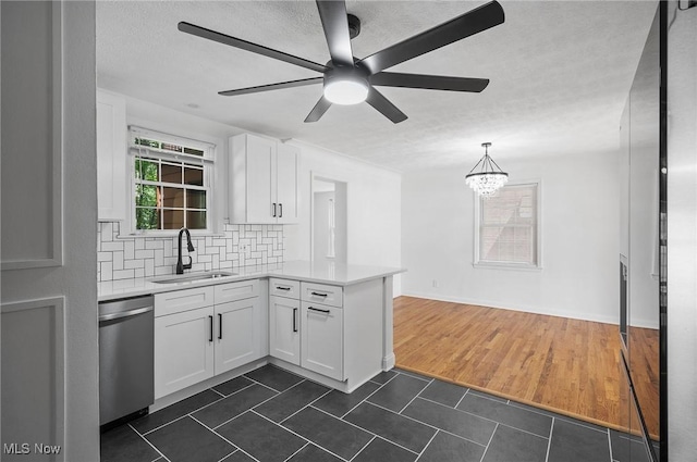 3722 Avalon Rd, Shaker Heights, OH 44120 - kitchen with stainless steel dishwasher, a peninsula, light countertops, white cabinetry, and dark tile patterned flooring