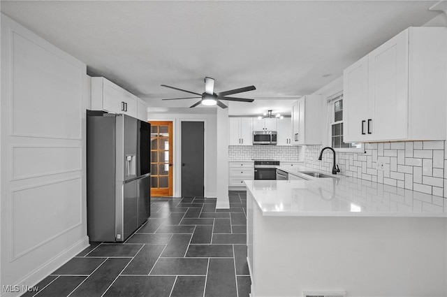 3722 Avalon Rd, Shaker Heights, OH 44120 - kitchen with stainless steel appliances, a ceiling fan, backsplash, a peninsula, and white cabinetry
