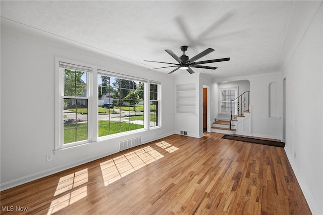 3722 Avalon Rd, Shaker Heights, OH 44120 - empty room with built in features, stairway, wood finished floors, and a ceiling fan