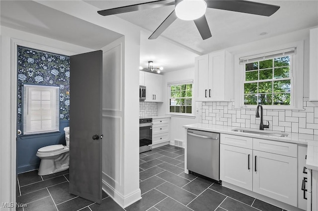 3722 Avalon Rd, Shaker Heights, OH 44120 - kitchen featuring stainless steel appliances, dark tile patterned floors, light countertops, and white cabinets
