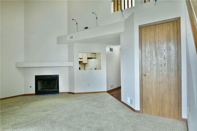 3406 Ivy Hill Cir Unit B, Cortland, OH 44410 - unfurnished living room featuring carpet flooring, a high ceiling, and a fireplace with flush hearth