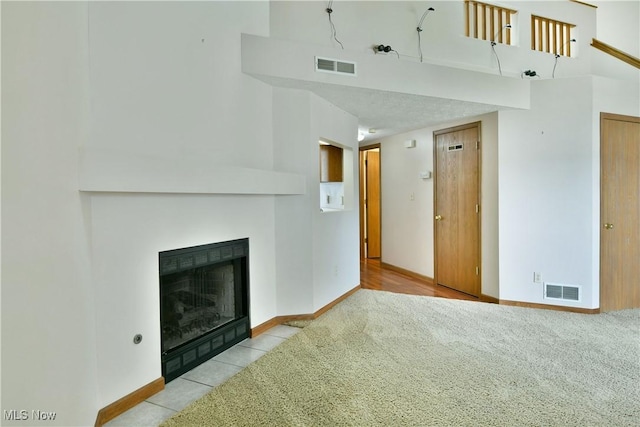 3406 Ivy Hill Cir Unit B, Cortland, OH 44410 - unfurnished living room with carpet flooring, a fireplace with flush hearth, and a towering ceiling