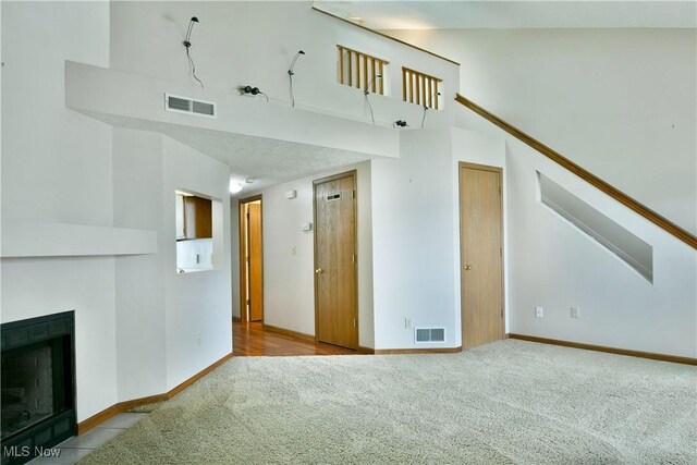 3406 Ivy Hill Cir Unit B, Cortland, OH 44410 - unfurnished living room with carpet flooring, a high ceiling, and a fireplace with flush hearth