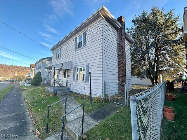 807 Daniels St, Toronto, OH 43964 - view of property exterior featuring a chimney and a gate