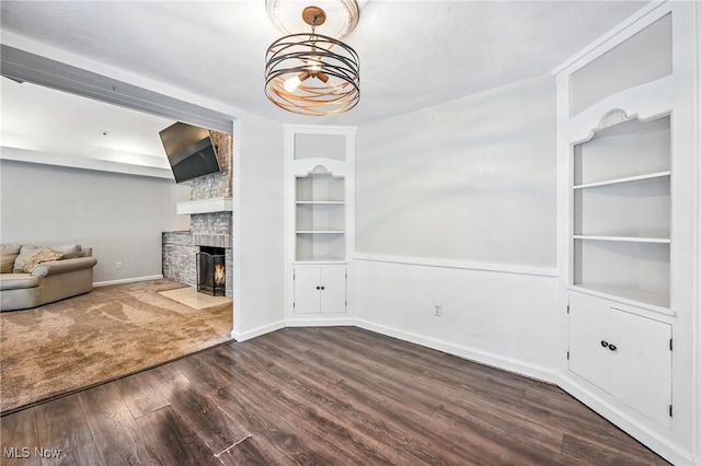 1130 Dairy Ln, East Liverpool, OH 43920 - unfurnished living room with built in shelves, a large fireplace, and dark wood-type flooring