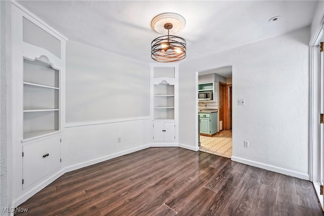 1130 Dairy Ln, East Liverpool, OH 43920 - unfurnished dining area with built in shelves and dark wood-style flooring