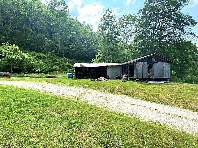 8710 Clay Rd, Left Hand, WV 25251 - view of side of property with a lawn, an outdoor structure, and a wooded view